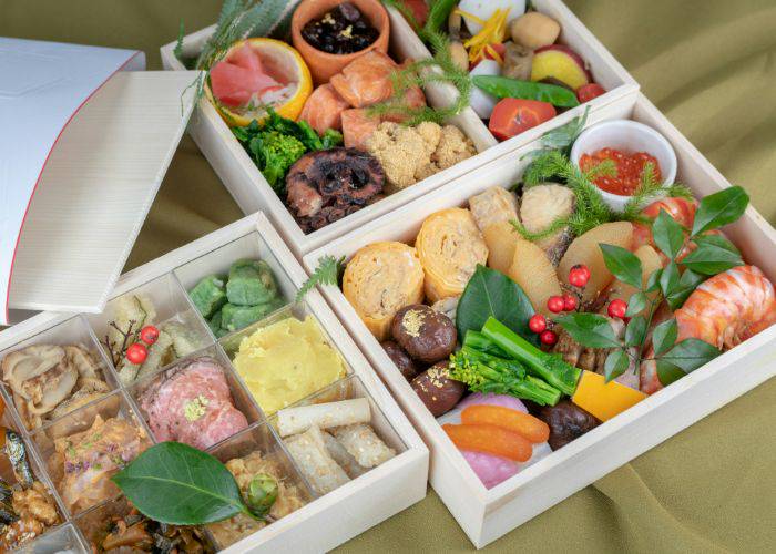 A selection of decorated bento boxes, filled with a variety of fresh seafood, egg and vegetables.